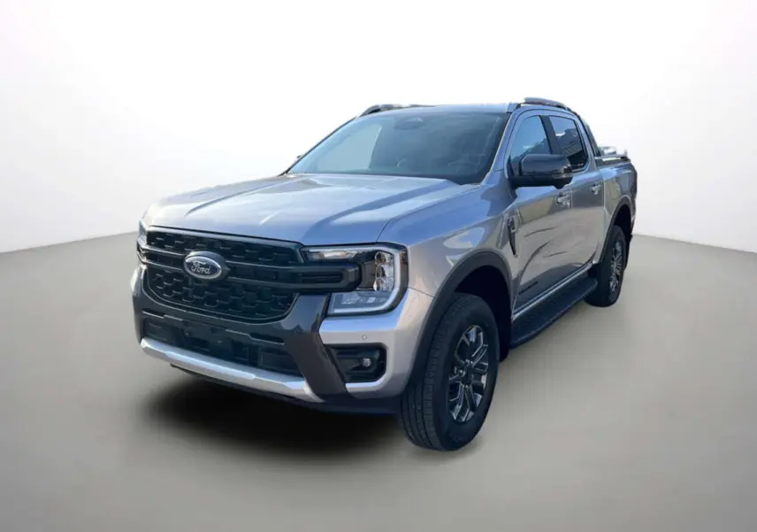 Ford Ranger 2.0 Wildtrak Plus gris iconic en 3/4 avant droit avec barres de toit et jantes alu 18 pouces.