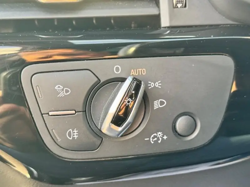 Gros plan sur la commande des phares noire et chrome de l'Audi S4 Avant 2017 avec réglage automatique et fonction antibrouillard.