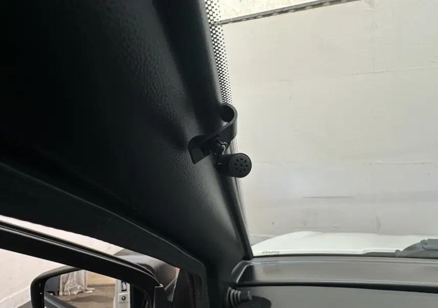 Vue intérieure côté gauche de l’AIXAM AMBITION 0.5 CITY PACK 2026 blanc, avec caméra intégrée au rétroviseur conducteur.