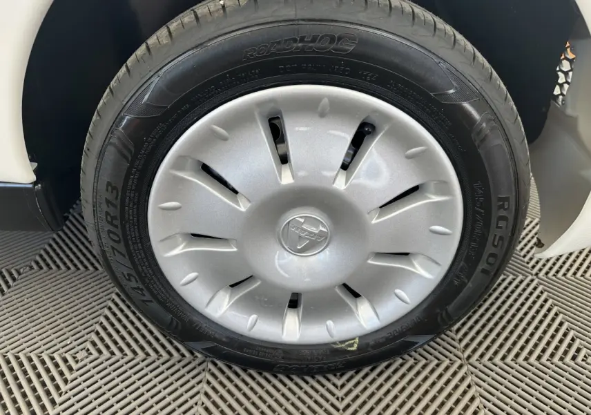 Gros plan sur la roue avant droite blanche de l'AIXAM AMBITION 0.5 CITY PACK avec jante argentée et pneu Roadhog.