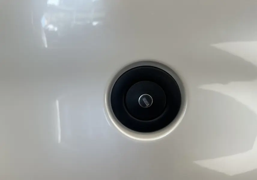 Gros plan sur le bouchon de réservoir noir circulaire sur la carrosserie blanche d'une Aixam Ambition 0.5 City Pack 2026.