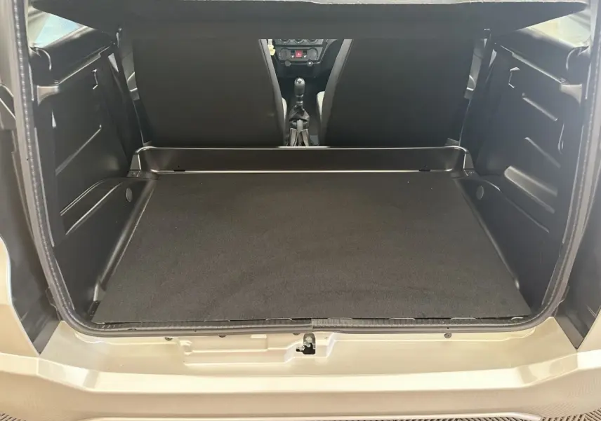 Vue arrière ouverte du coffre spacieux de l'AIXAM AMBITION 0.5 CITY PACK blanc, intérieur noir minimaliste.