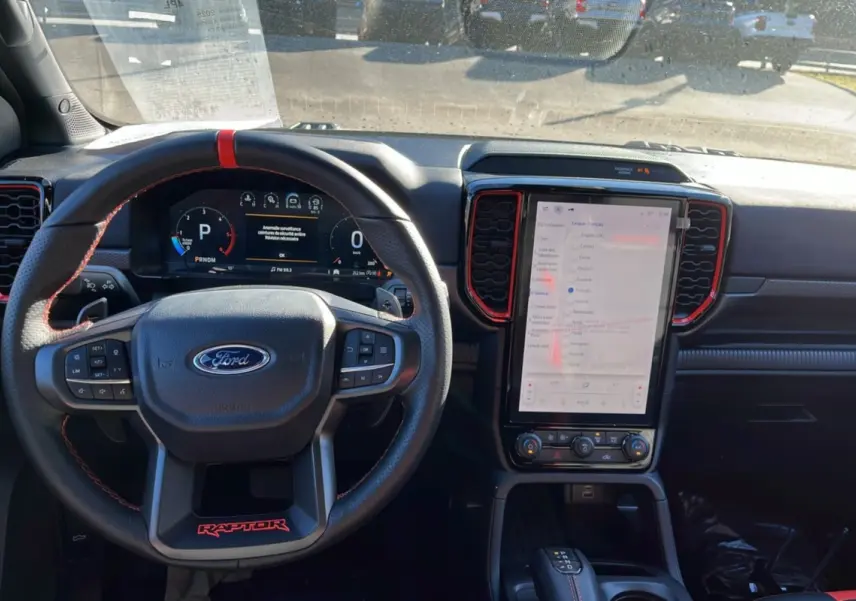 Vue intérieure centrée sur le volant cuir Raptor et l’écran tactile vertical du Ford Ranger gris commandeur 2025.