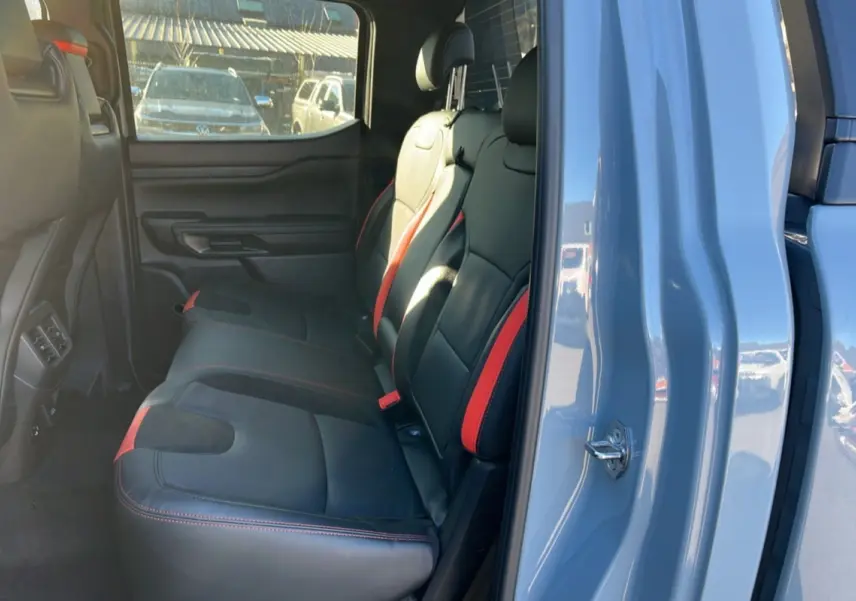 Vue intérieure côté gauche sur les sièges arrière noirs avec surpiqûres rouges du Ford Ranger Raptor 2025 gris commandeur.