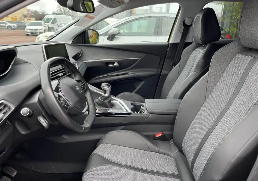 Vue intérieure côté conducteur du Peugeot 3008 2017, montrant la sellerie TEP et tissu grise et la boîte manuelle.