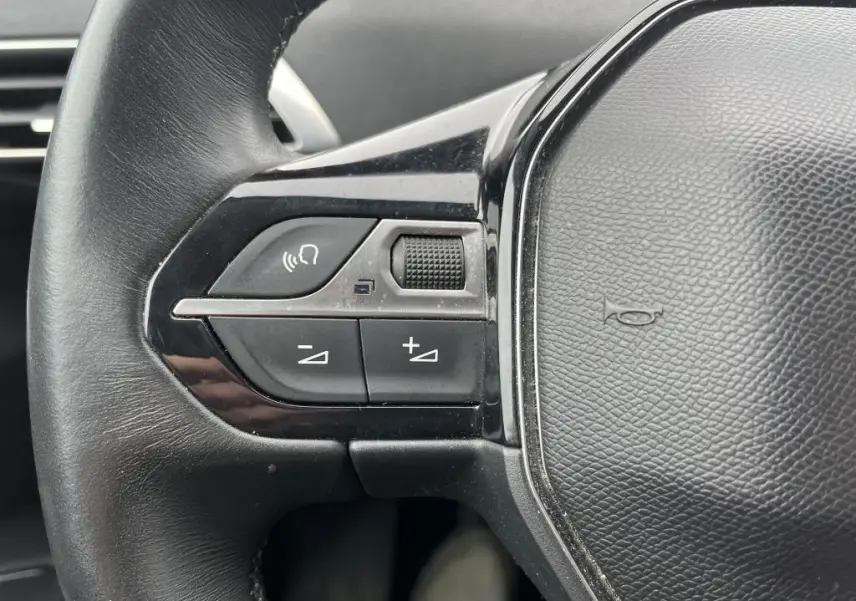 Gros plan sur les commandes gauche du volant noir du Peugeot 3008 2017, avec boutons de volume et téléphone.