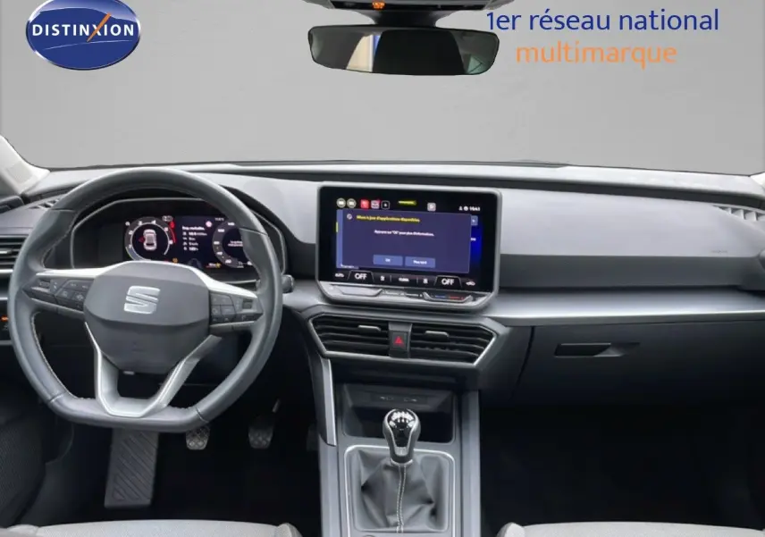 Vue intérieure frontale du tableau de bord et volant de la SEAT LEON 2025 avec écran tactile et boîte manuelle.