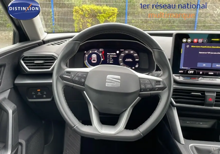 Vue centrée sur le volant cuir et le tableau de bord numérique de la SEAT LEON 2.0 TDI 2025, intérieur gris noir.