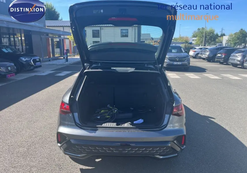 Vue arrière d'une Audi A3 Sportback gris Daytona avec coffre ouvert montrant le chargeur hybride rechargeable.