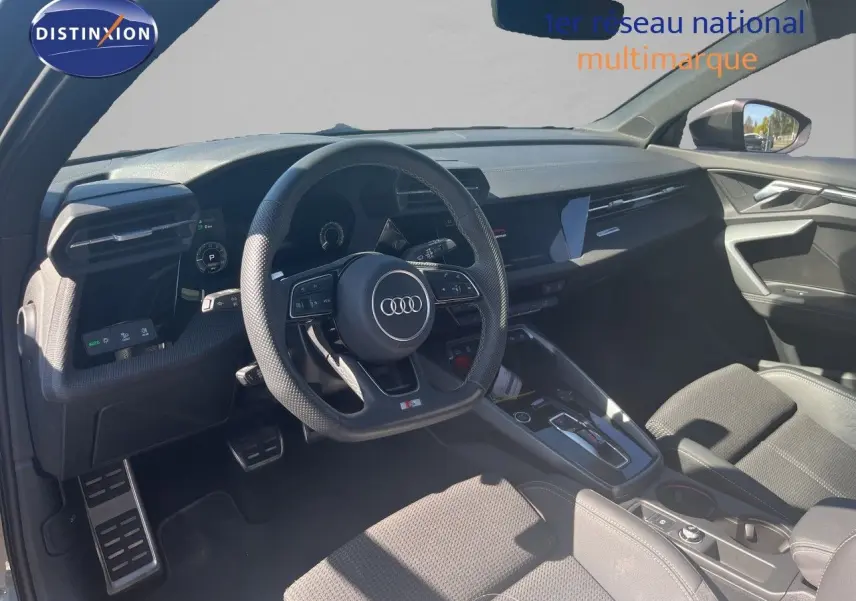 Intérieur de l'Audi A3 Sportback 40 TFSIe 2025 vu côté conducteur, tableau de bord noir et volant multifonction S-Line.