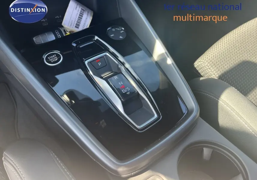 Gros plan sur la console centrale de l'Audi A3 Sportback 40 TFSIe 2025 avec levier de vitesse automatique et bouton start/stop.