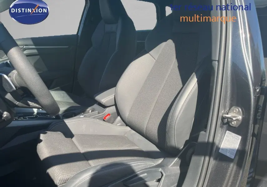 Vue intérieure côté conducteur de l'Audi A3 Sportback gris Daytona, mettant en valeur les sièges en tissu et cuir noir.