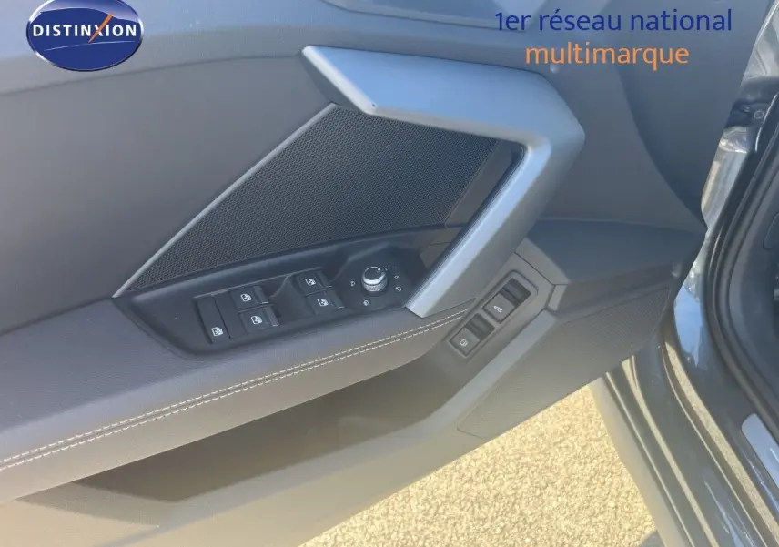 Détail de la porte avant gauche de l'Audi A3 Sportback gris Daytona, montrant les commandes des vitres et rétroviseurs.
