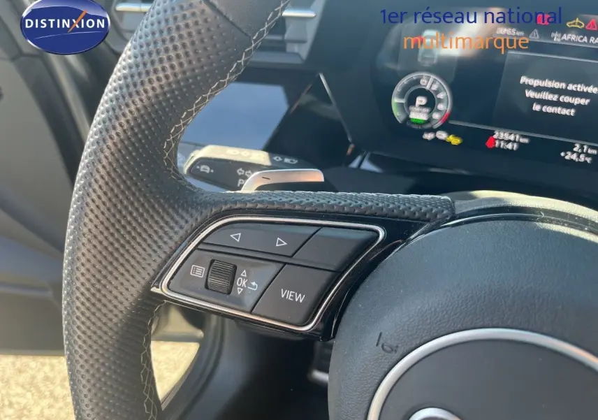 Gros plan sur le volant perforé et les commandes multifonctions de l'Audi A3 Sportback 40 TFSIe S-Line 2025.