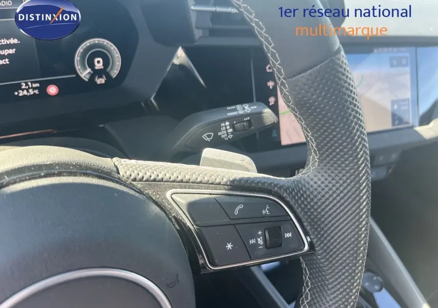 Gros plan sur le volant en cuir perforé avec commandes intégrées et tableau de bord numérique de l'Audi A3 Sportback 2025.