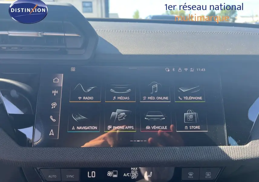 Écran tactile central de l'Audi A3 Sportback 2025 affichant les menus multimédia et navigation, avec tableau de bord noir.