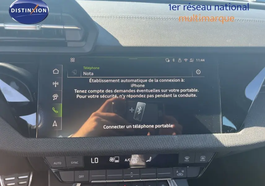 Vue intérieure du tableau de bord de l'Audi A3 Sportback gris Daytona, écran tactile central avec connectivité téléphone visible.