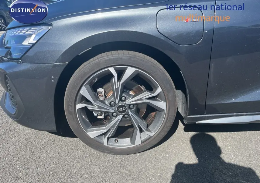 Gros plan sur la roue avant gauche d’une Audi A3 Sportback gris Daytona avec jante alliage S-Line.