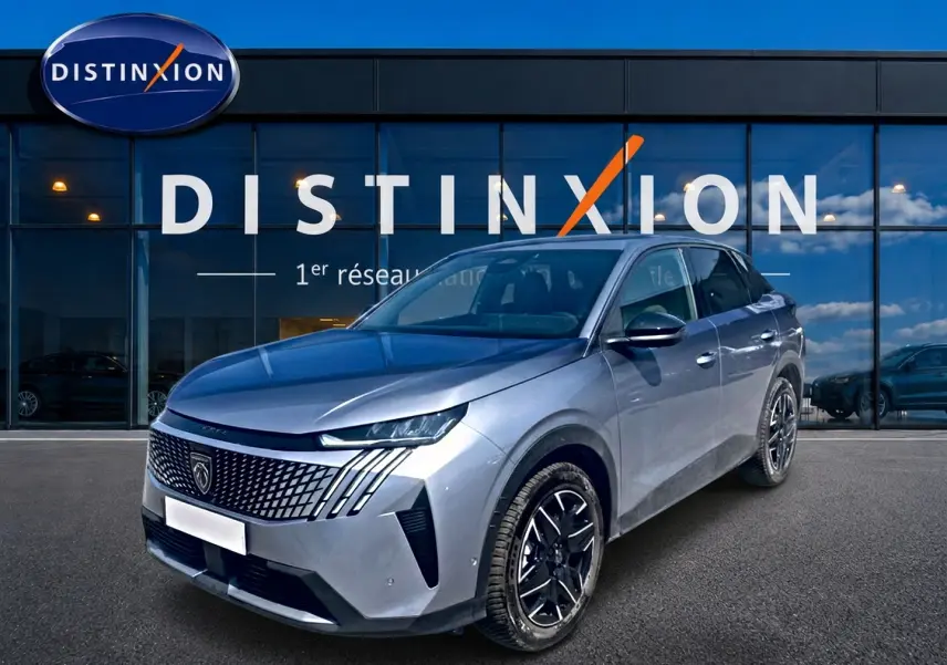 Peugeot 3008 gris en 3/4 avant droit, avec calandre distinctive et jantes alliage noires devant showroom Distinxion.
