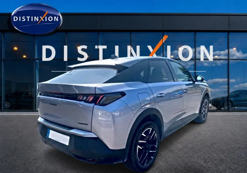 Peugeot 3008 gris vue 3/4 arrière droit, avec jantes alu noires et toit noir contrasté, devant un bâtiment Distinxion.