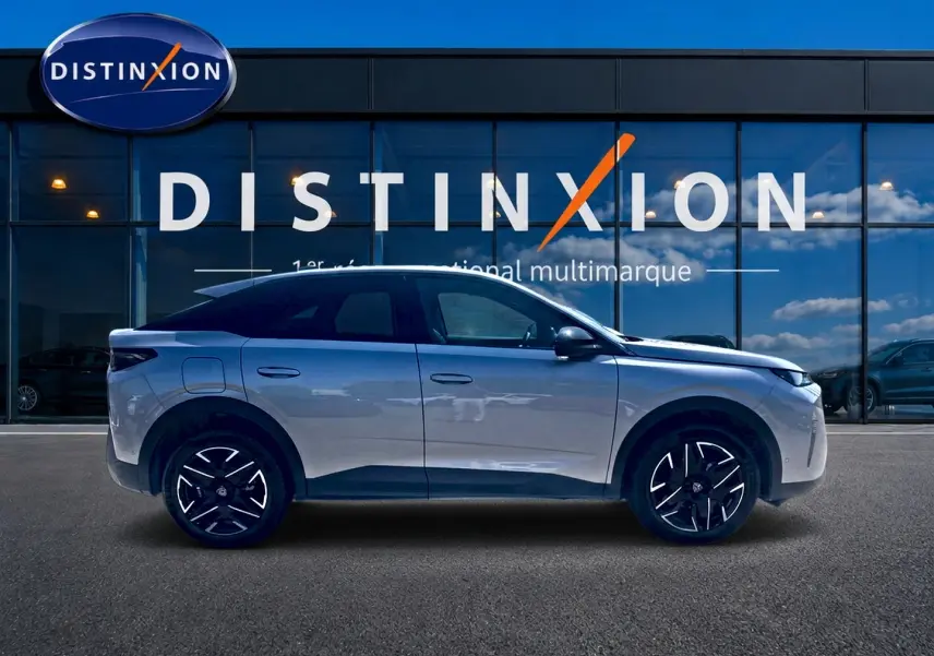 Profil côté gauche du Peugeot 3008 gris 2025 devant une vitrine avec logo Distinxion.