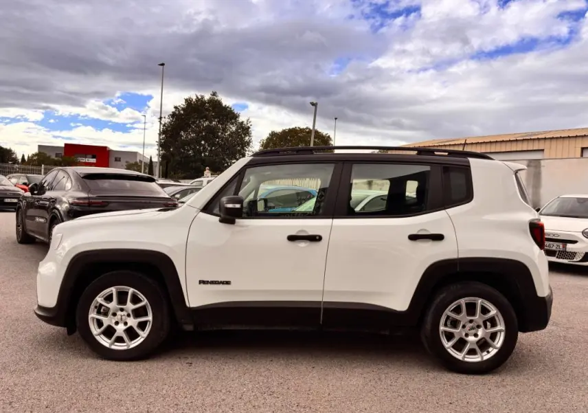 Jeep Renegade blanc vue de profil côté gauche, avec jantes argentées et éléments noirs contrastants sur les passages de roues.