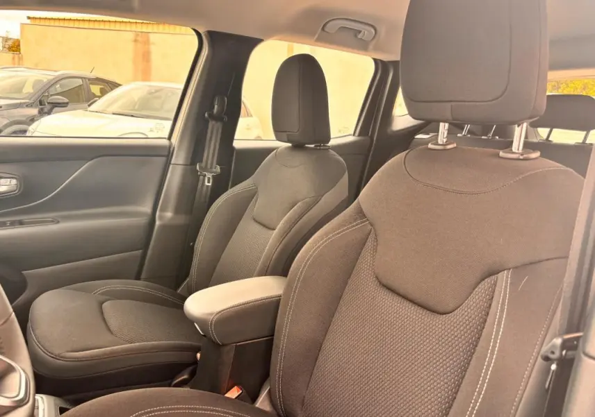 Vue intérieure des sièges avant en tissu noir du Jeep Renegade 2024, côté droit, avec accoudoir central visible.