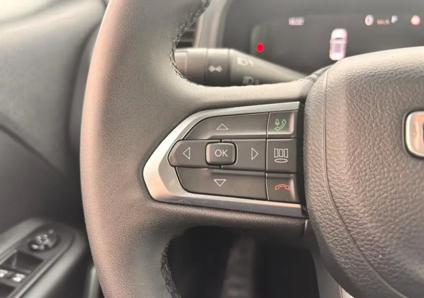 Gros plan sur les commandes au volant côté gauche du Jeep Renegade 2024, avec boutons multifonctions et finition noire.