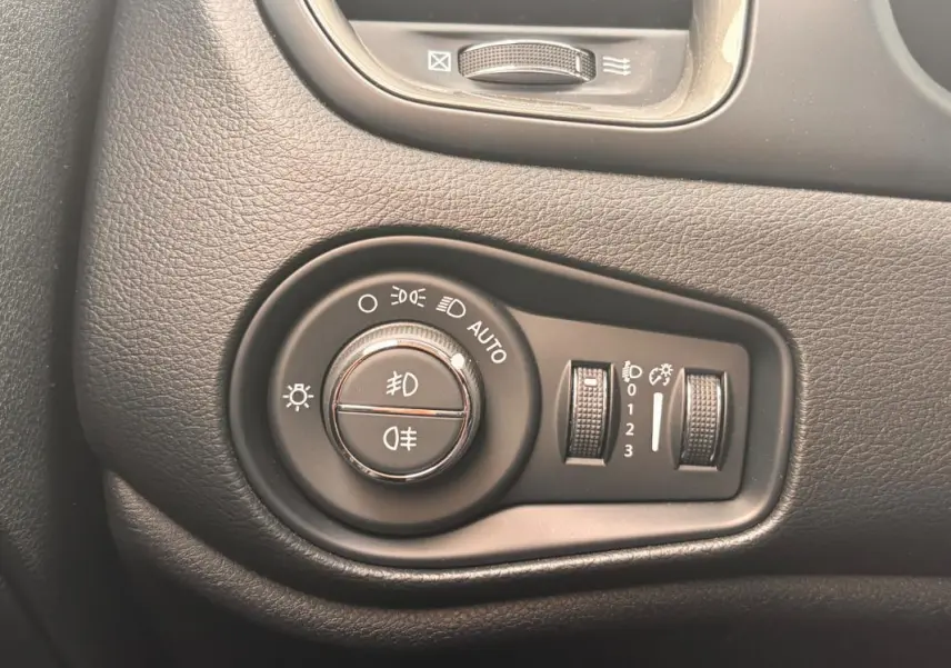 Gros plan sur la molette de commande des phares du tableau de bord du Jeep Renegade 2024, finition Altitude.