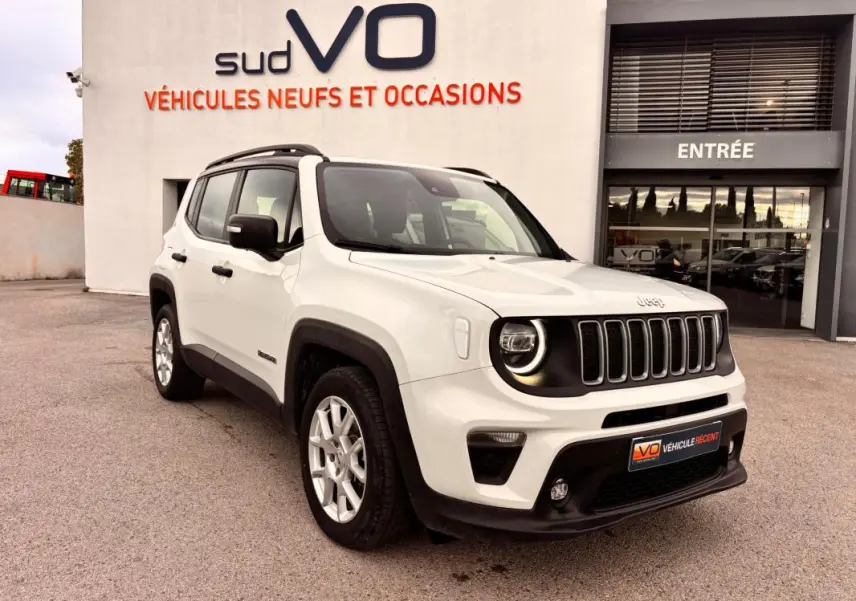 Vue 3/4 avant droite d’un Jeep Renegade blanc 2024 avec calandre noire et jantes argentées, devant un showroom.