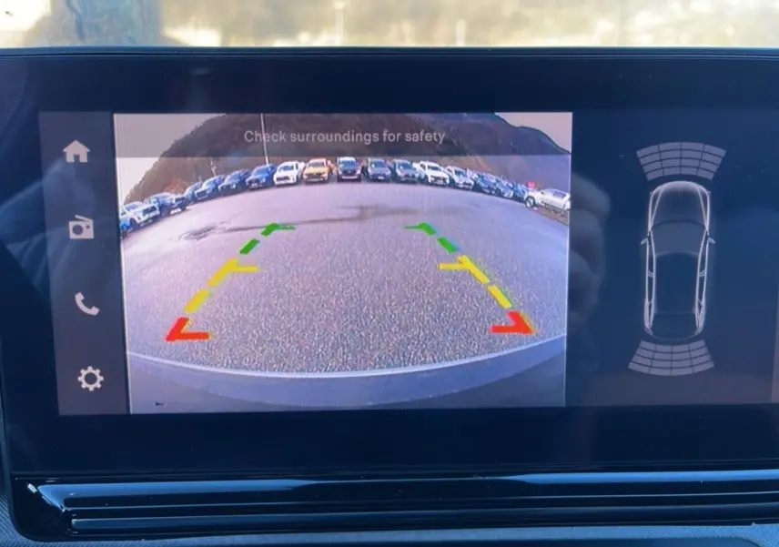 Vue de l'écran tactile de la Citroën C3 Aircross montrant la caméra de recul avec guidage coloré et capteurs de proximité.