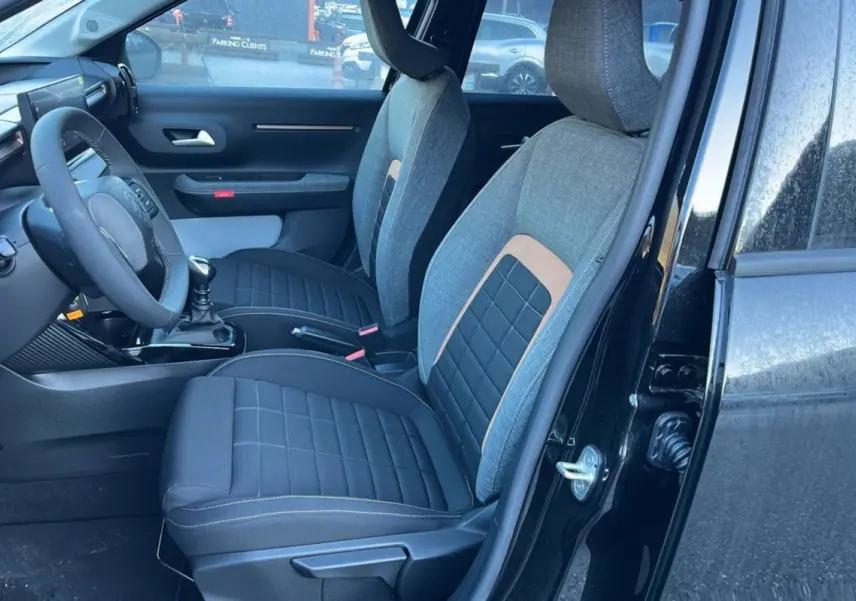 Vue intérieure côté conducteur de la Citroën C3 Aircross noire, sièges tissu bi-matière gris et noir avec surpiqûres.