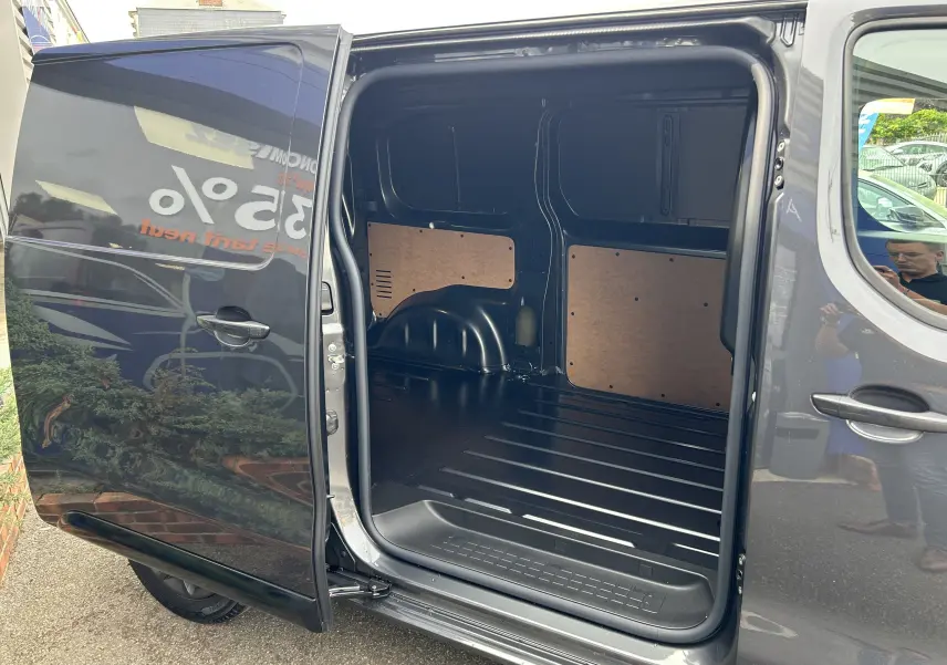 Vue latérale du Citroën Jumpy gris titane 2025 avec porte coulissante ouverte montrant l’espace de chargement vide.