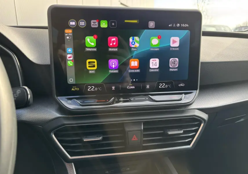 Vue rapprochée de l’écran tactile central du tableau de bord du SEAT Leon 2025, affichant l’interface Apple CarPlay.