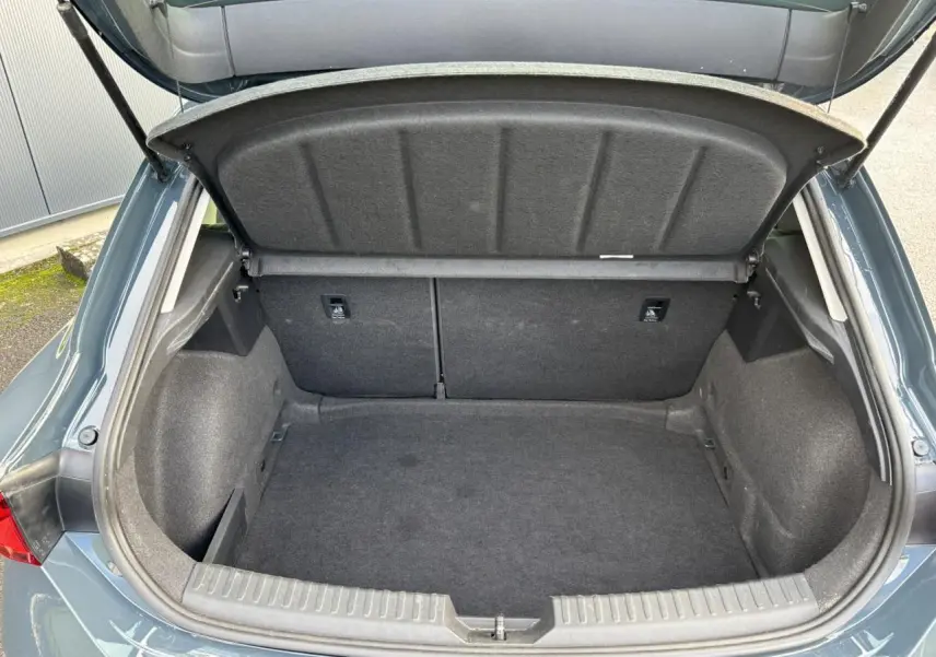 Coffre ouvert vu de l'arrière d'une SEAT Leon 2.0 TDI 115 Style bleu Fjord, montrant l'espace de chargement vide.