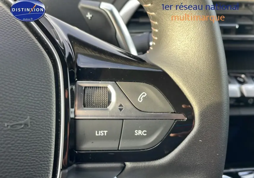 Gros plan sur les commandes audio au volant cuir noir du Peugeot 3008 Plug-in Hybrid 2024, côté gauche.