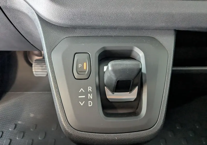 Gros plan sur le levier de vitesses automatique noir du Renault Trafic Cabine Approfondie 2025, avec bouton parking éclairé.