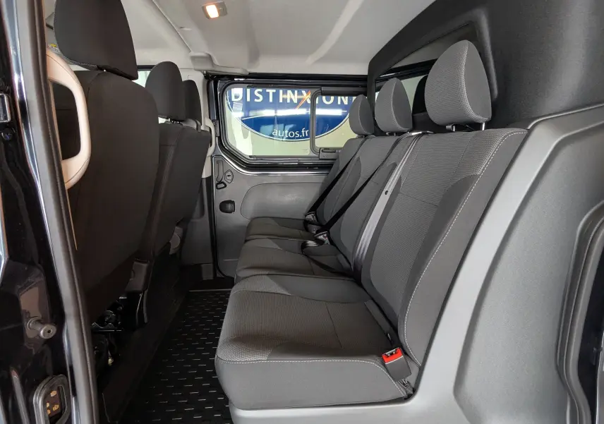 Vue latérale intérieure montrant la banquette arrière grise du Renault Trafic Cabine Approfondie L2H1 2025.