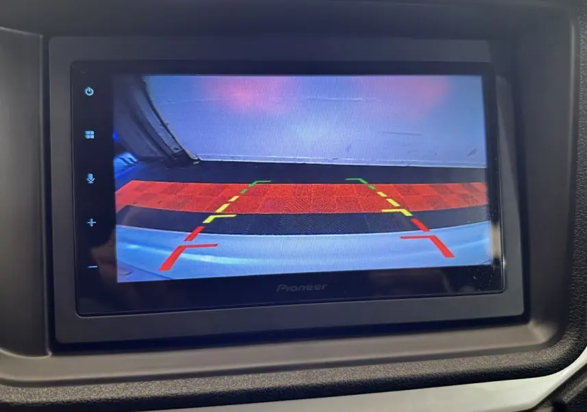 Écran de caméra de recul affichant les lignes de guidage, dans l'habitacle d'une Aixam Ambition blanche 2026.