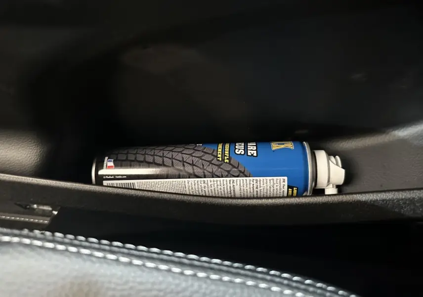 Gros plan sur un aérosol de produit dans la porte côté conducteur d’une Aixam Ambition 0.5 Crossover Premium blanche.