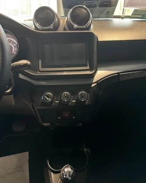 Vue intérieure centrée sur la console centrale de l'AIXAM AMBITION 0.5 CROSSOVER PREMIUM blanche, avec écran tactile et commandes de climatisation.