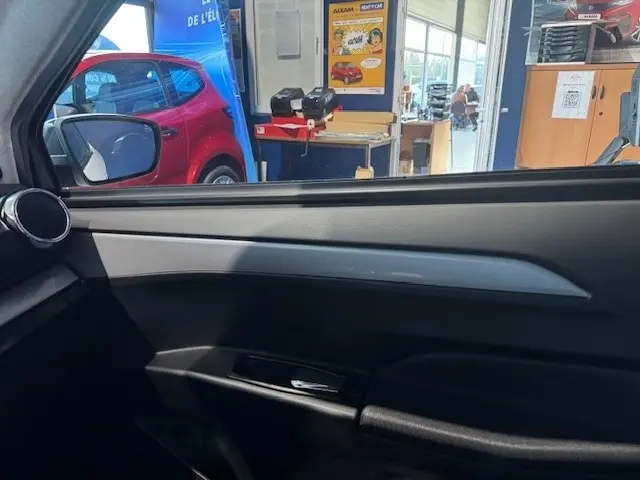 Vue intérieure côté conducteur de la porte noire de l'AIXAM AMBITION 0.5 CROSSOVER PREMIUM 2026 avec rétroviseur caméra.
