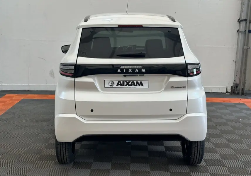 Vue arrière d'une Aixam Ambition 0.5 Crossover Premium blanche, avec logo et feux arrière noirs contrastants.