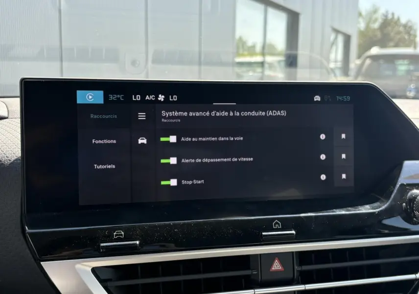 Écran tactile central du tableau de bord de la Citroën C4 Hybrid 145 blanc montrant les aides à la conduite activées.