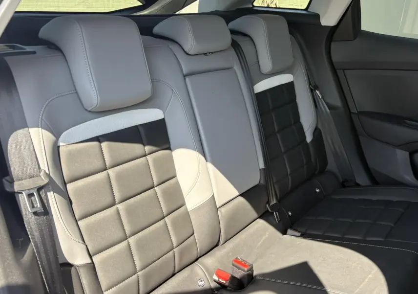 Vue intérieure arrière des sièges en tissu noir et gris clair de la Citroën C4 Hybrid 2025, ambiance Metropolitan Grey.