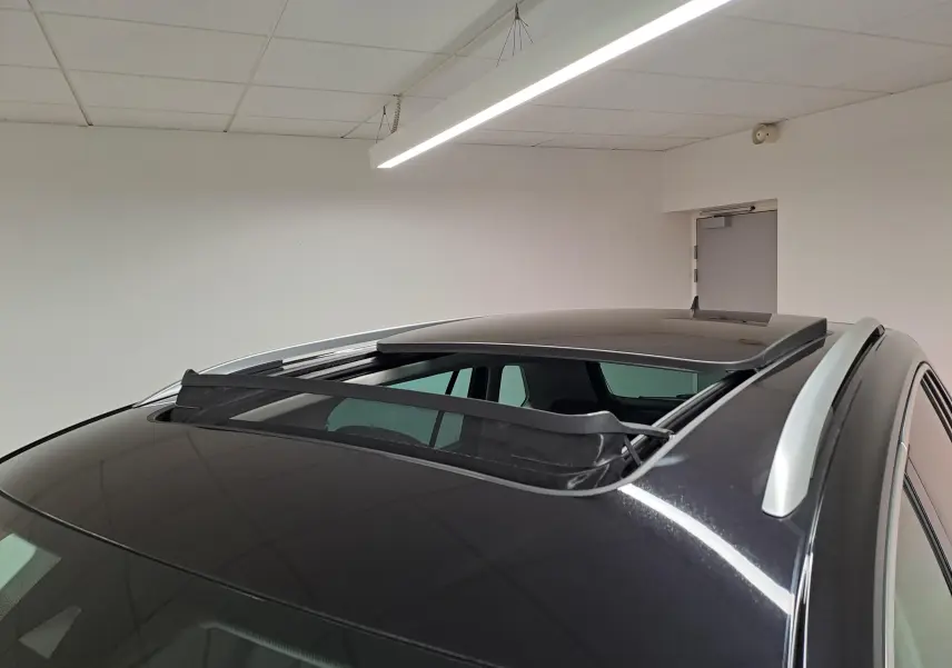 Vue en plongée du toit noir intense du Volkswagen Tiguan 2022 avec toit ouvrant panoramique partiellement ouvert.