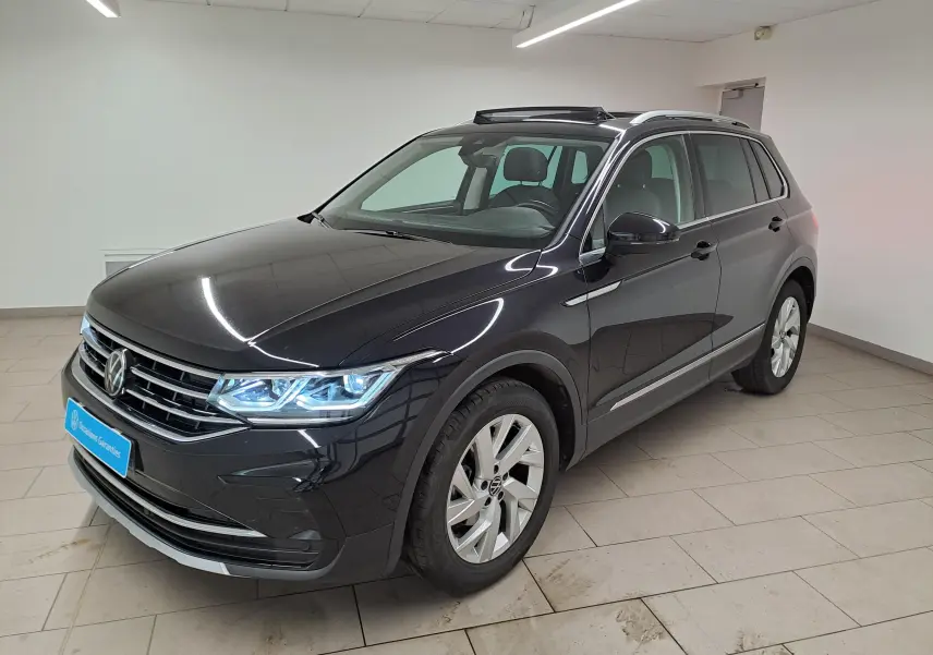 Volkswagen Tiguan 2.0 TDI 150 DSG7 Elegance noir intense, vue 3/4 avant droit avec phares allumés en intérieur.