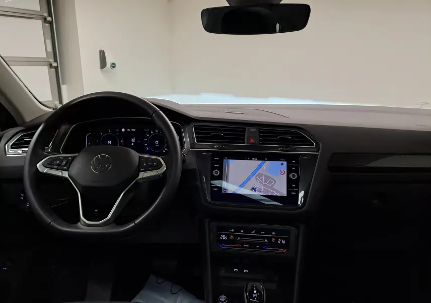 Vue intérieure frontale du tableau de bord du Volkswagen Tiguan 2022 avec écran tactile et volant multifonction noir.