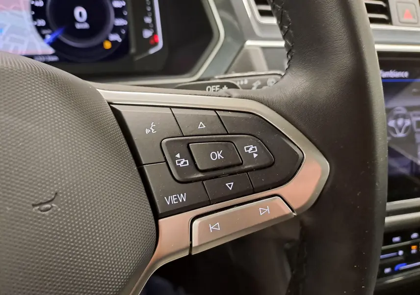 Gros plan sur les commandes multifonctions à droite du volant du Volkswagen Tiguan 2022, finition Elegance, intérieur noir.