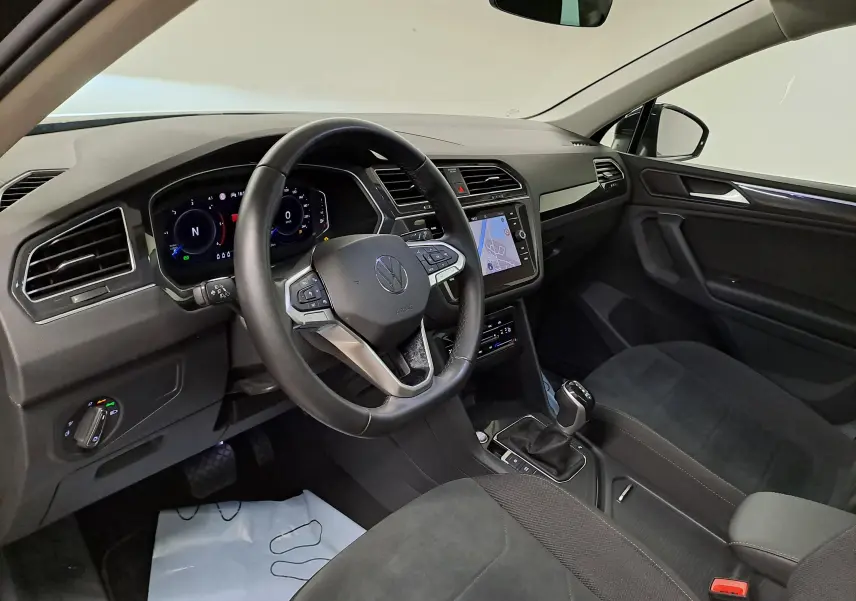 Vue intérieure côté conducteur du Volkswagen Tiguan 2022, tableau de bord moderne avec écran tactile et volant multifonction.